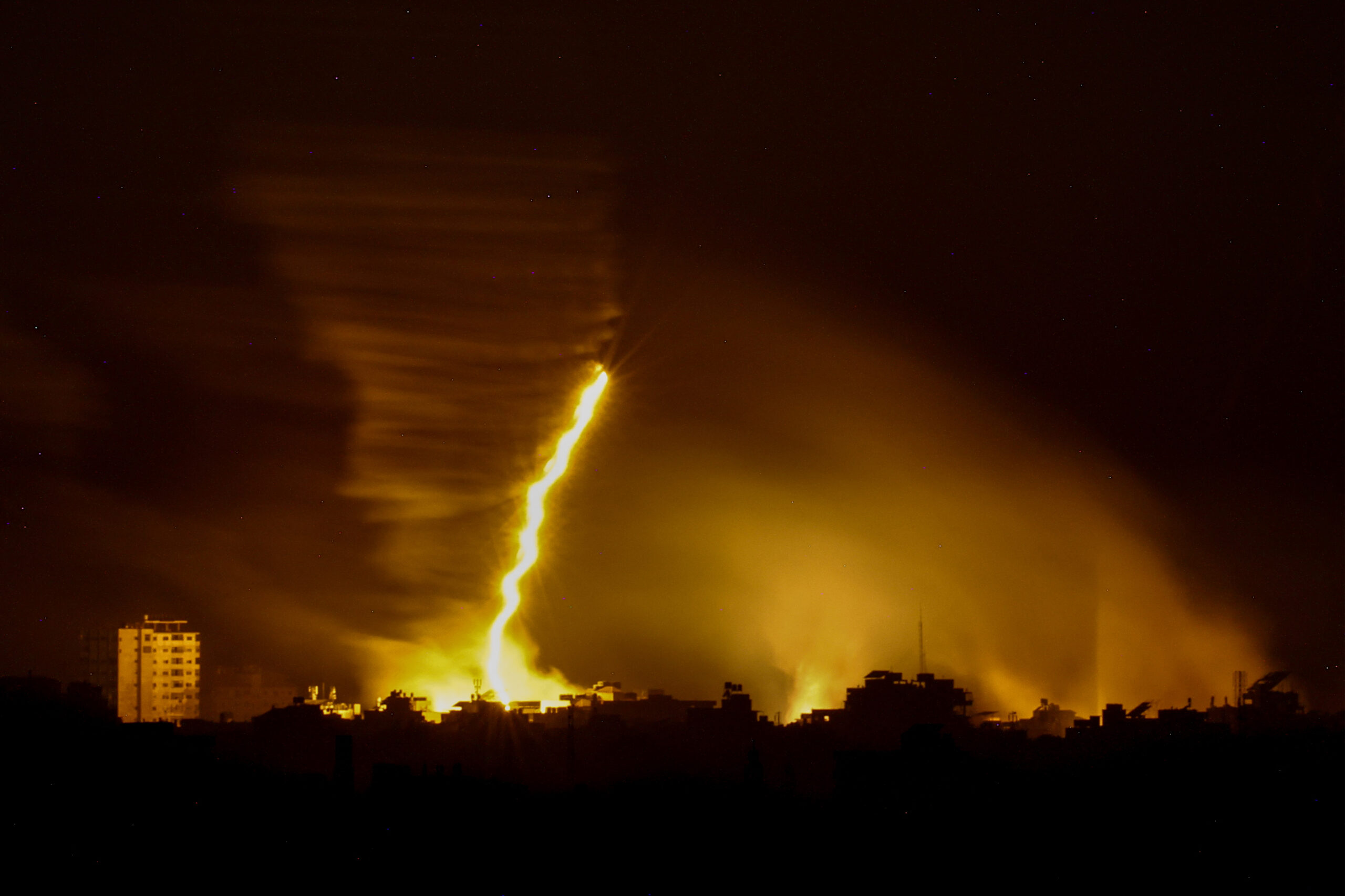 This picture taken from the Israeli side of the border with the Gaza Strip, shows flares being fired by Israeli troops over the Gaza Strip during Israeli bombardment amid ongoing battles with the Palestinian Hamas movement. (Photo by Kenzo TRIBOUILLARD / AFP)